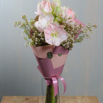 Meilenių puokštė rožiniame popieriuje vazoje